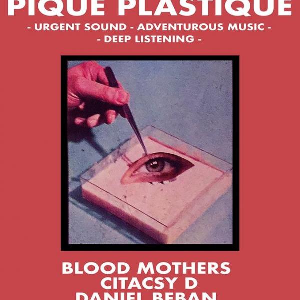 A hand with tweezers plucking an eye in a petri dish