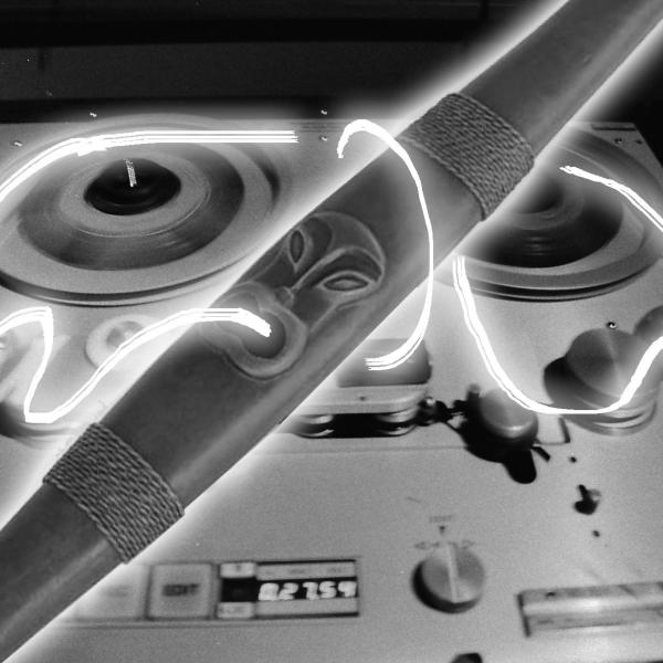 a pūtōrino is aglow, white neon magnetic tape cascading around it and fusing it to a reel to reel