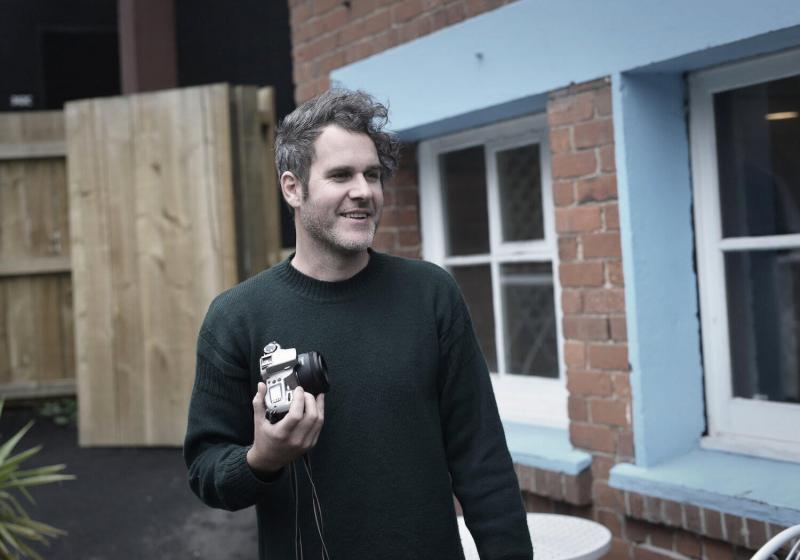 Christopher Schmelz holding an SLR camera