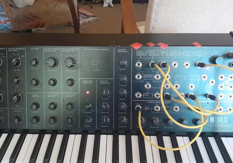 A korg MS-20 Synthesiser in a messy lounge