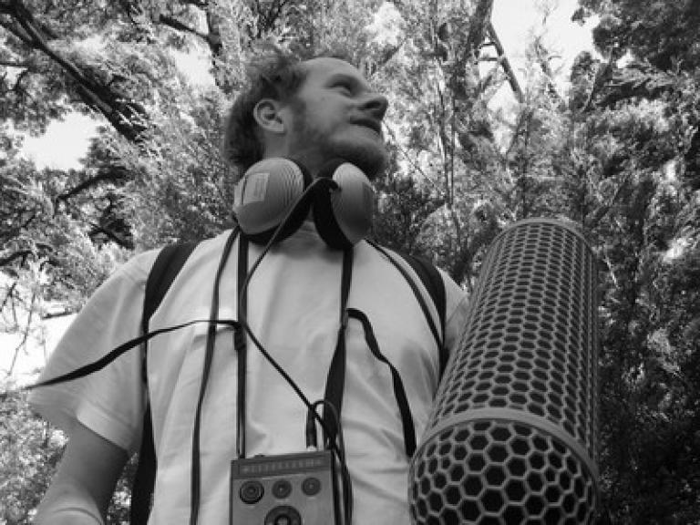 Reuben in a forest with recording equipment