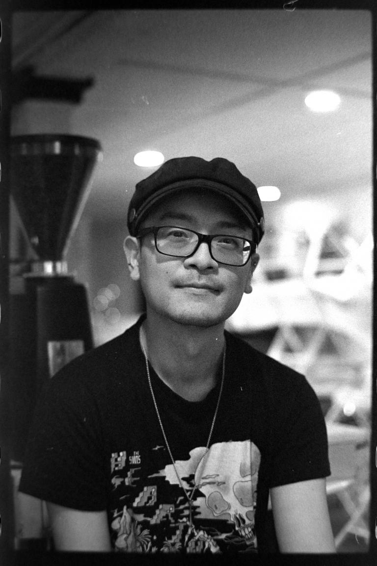 a person sitting in front of a full coffee grinder