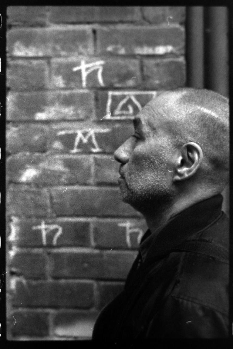 a profile shot of someone with a shaved head and stubbled face